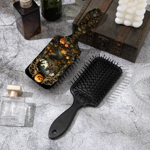 Detail view of two massage hairbrushes with festive Halloween pumpkin and castle prints
