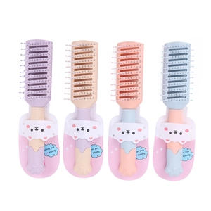 Detail view of four macaron-colored hairbrushes with cute 3D cat paw handles in packaging