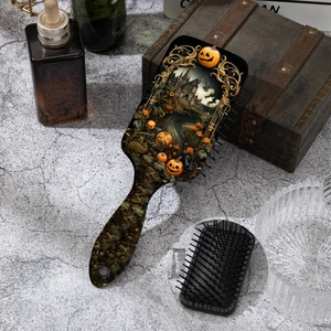 Detail of Halloween pumpkin print hairbrush with massage bristles on marble background