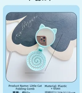 Detail of blue cat-shaped folding travel hair brush with integrated circular mirror