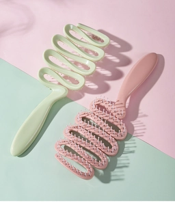 Nahaufnahme hohler Spiral-Haarbürsten mit Massageborsten in Rosa und Grün