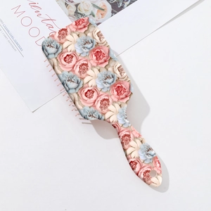 Détail de brosse à cheveux à motif floral 3D avec poignée ergonomique pratique