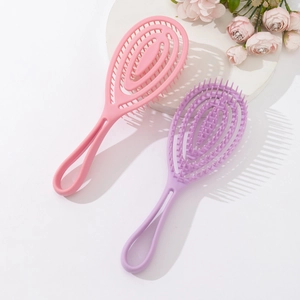 Pink and purple spiral vented hairbrushes on a white pedestal with floral accents