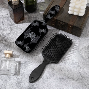 Gothic Halloween hair brush set with black lace bat print on a gray concrete background