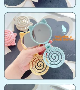 Close-up of a portable folding cat-ear hairbrush with an integrated small mirror