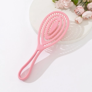 Pink vented hairbrush for scalp massage and volume styling on white aesthetic pedestal