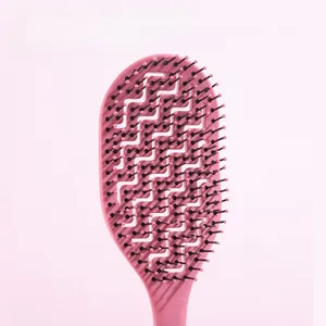 Détail de la brosse à cheveux rose avec design creusé en S et picots de massage du cuir chevelu