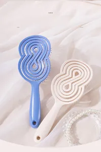 Détail de la brosse à cheveux creuse beige et violette au design ouvert thermique