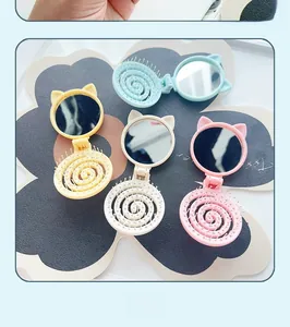 Macro view of portable cat-ear folding hairbrush with built-in mirror in candy colors