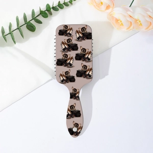 Gros plan d'une brosse à cheveux à coussin d'air carrée avec imprimé chiot mignon