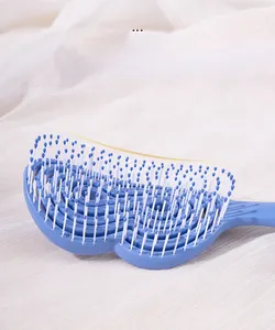 Détail de la brosse à cheveux bleue courbée ajourée avec picots de massage