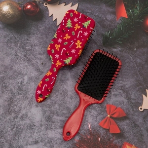 Detailed view of red Christmas hairbrushes with gingerbread man and holiday patterns