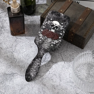 Detail der Gothic-Haarbürste mit weißem Totenkopf und roten Rosen auf antikem Hintergrund