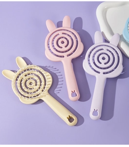Macro detail of macaron-colored hollow hairbrushes with cute rabbit ears and spiral design