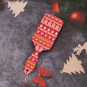 Detail of Christmas reindeer hairbrush with red festive prints on a holiday background