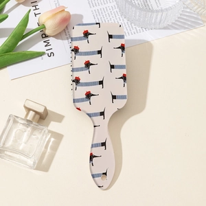 Détail de brosse à cheveux avec motif teckel et manche ergonomique sur fond beige