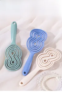Détail de brosses à cheveux massantes incurvées en vert menthe, bleu ciel et beige
