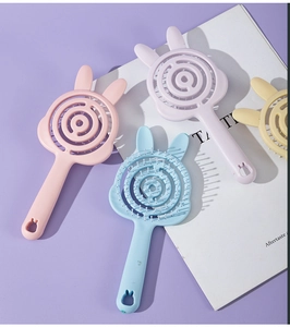 Macro detail of rabbit shaped hollow hairbrushes in pastel pink purple blue and yellow