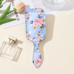 Close-up of floral air cushion hairbrush with rose pattern on elegant vintage background