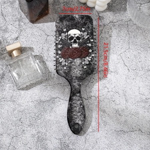 Detailansicht von Totenkopf und Rosen-Aufdruck auf einer mattschwarzen Haarbürste