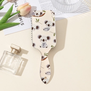 Détail d'une brosse à cheveux beige avec motifs koala mignons et trou de suspension utile
