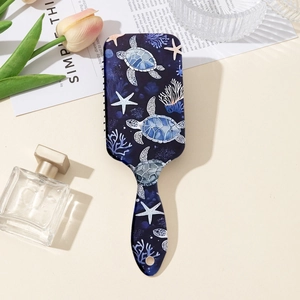 Detail of cushion hairbrush featuring sea turtle print and soft scalp massage bristles