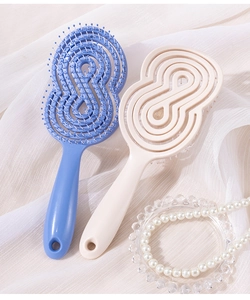 Détail de brosses à cheveux évidées bleues et crème avec poils massants sur soie