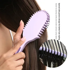 Dettaglio della spazzola massaggiante viola con scanalature laterali per lo styling dei capelli