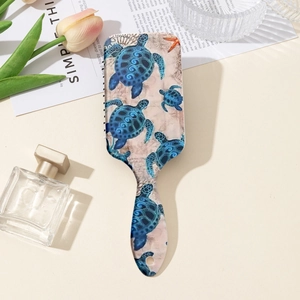 Detail of paddle hairbrush featuring sea turtle prints and massaging air cushion base
