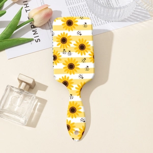 Dettaglio di una spazzola per capelli con stampa di girasoli e api in un ambiente elegante