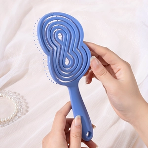 Brosse démêlante creuse bleu Morandi avec picots massants sur fond de soie