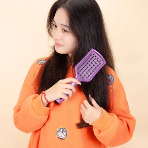 Professional purple vented hair brush for detangling and blow-drying with ergonomic design