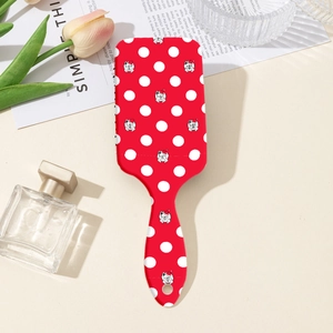 Détail de la brosse à cheveux bouledogue français rouge avec pois blancs sur table