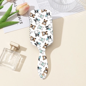 Détail d'une brosse à cheveux blanche avec imprimé bouledogue et picots de massage