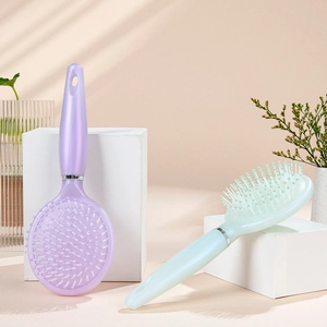 Ergonomic massage hair brush set in light purple and mint green on white platform