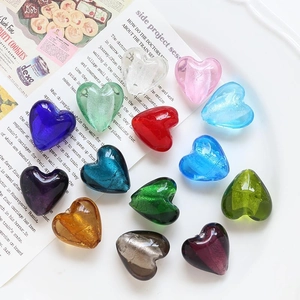 Vista macro di perle di vetro colorate a forma di cuore per accessori gioielli fai da te