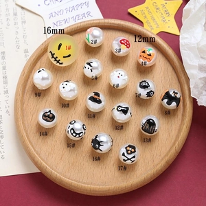 Detailed view of Halloween themed acrylic beads with ghost and pumpkin patterns for DIY