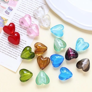 Perle di vetro colorate a forma di cuore per gioielli fai-da-te in un piatto di porcellana