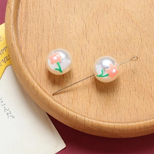 Macro view of DIY round beads with pink flower prints and horizontal drill holes