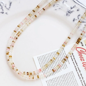 Close-up of mixed amber, pink, and transparent agate beads for DIY jewelry making