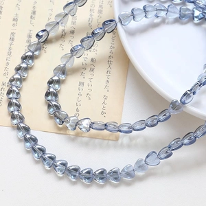 Close-up of translucent blue heart-shaped glass beads for DIY jewelry making