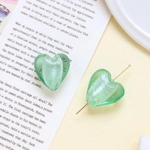 Dettaglio di perline di vetro a cuore verde menta glitterate per gioielli fai-da-te