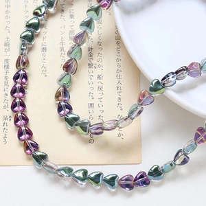 Macro shot of iridescent heart-shaped glass beads with electroplated metallic luster