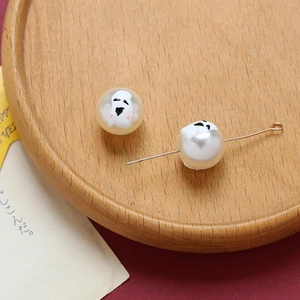 Close-up of Halloween ghost beads for DIY jewelry with white pumpkin ghost patterns