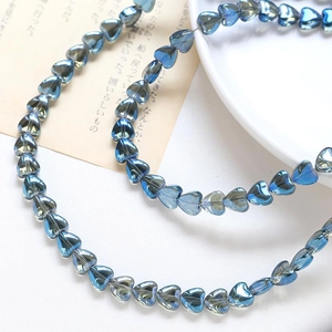 Macro shot of blue transparent heart-shaped beads for DIY jewelry and necklace crafting