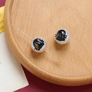 Macro shot of Halloween white ghost pearls with RIP print and metal pin for DIY jewelry