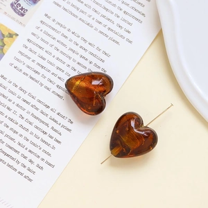 Dettaglio macro di perline di vetro a cuore ambrato con texture naturale per gioielli fai-da-te
