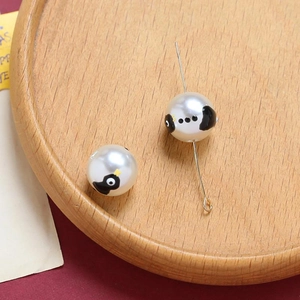 Macro detail of Halloween ghost pumpkin print beads with silver pins for DIY jewelry making