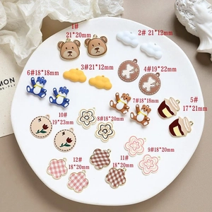 Detail view of 12 cartoon bear and flower alloy charms with size measurements