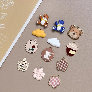 Flat lay of colorful DIY resin charms featuring cartoon bears and flowers for jewelry